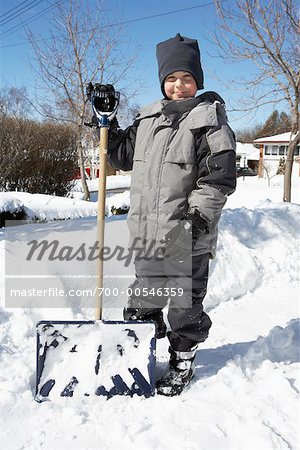Junge stand neben Schneeschaufel im Winter