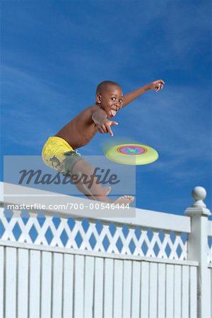 Junge werfen Frisbee über Zaun