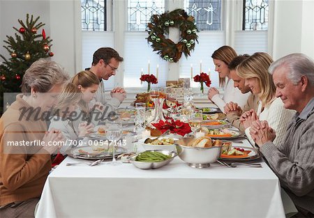 Family Praying at Christmas Dinner