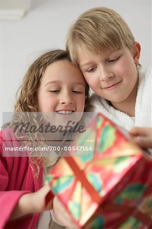 Garçon et fille regardant un cadeau de Noël