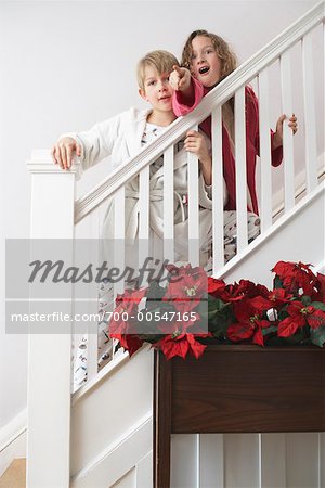 Garçon et fille en bas à venir le matin de Noël