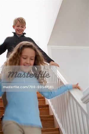 Girl and Boy Running Down Stairs