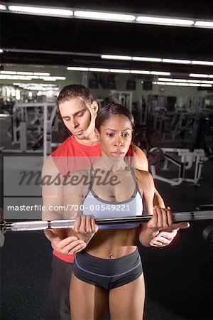 Femme, soulever des poids avec Personal Trainer