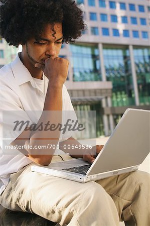 Man in einer Stadt mit Laptop