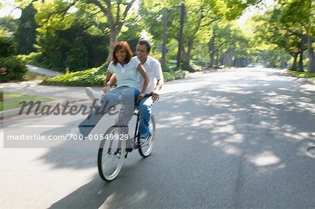 Couple Riding on Bicycle Together, Woman Sitting on Handlebars
