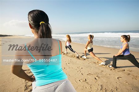 Frauen tun Stretching-Übungen am Strand