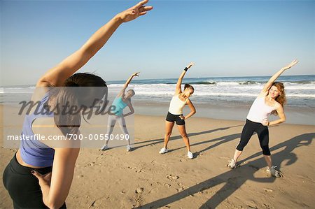Femmes faisant des exercices d'étirement sur la plage