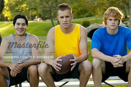 Three Young Men Sitting In Park