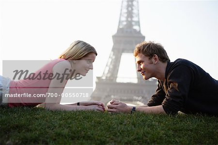 Couple allongé par la tour Eiffel, Paris, France