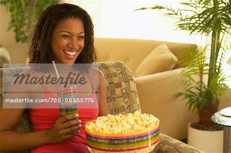 Woman Eating Popcorn and Drinking Beverage