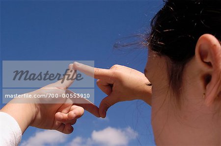 Mädchen-Framing-Himmel mit Fingern