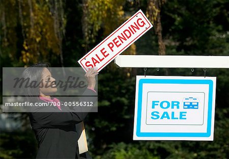 Realtor with Sale Pending Sign