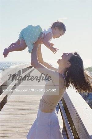 Mother Lifting Child at Beach