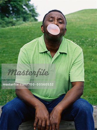Homme assis soufflant des bulles