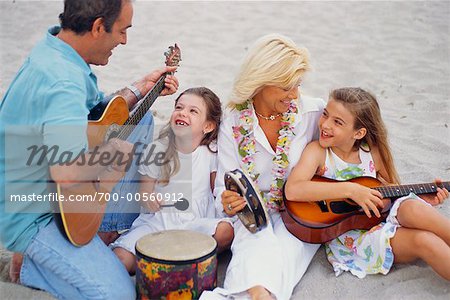 Famille jouant de la musique sur la plage