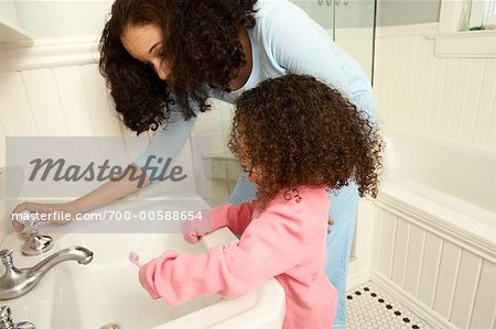Mädchen putzen Zähne mit Mutter