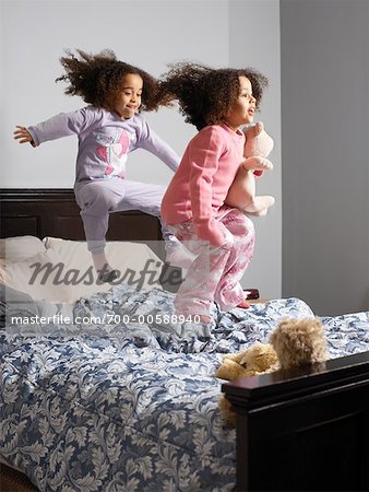 Zwei Mädchen auf dem Bett springen
