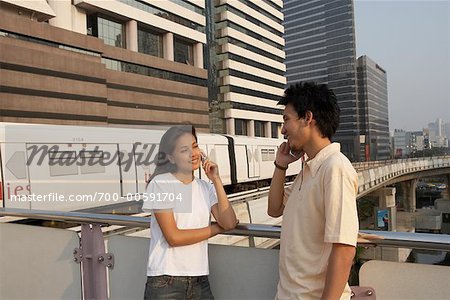 Homme et femme de parler sur les téléphones cellulaires Homme et femme de parler sur les téléphones cellulaires
