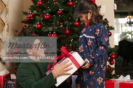 Brother Handing Sister Present on Christmas Morning