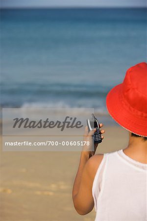 Woman With Cellular Phone On The Beach