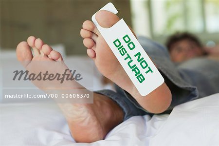 Man's Feet with Do Not Disturb Sign
