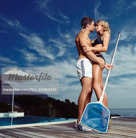 Pool Boy Embracing Woman in Bikini