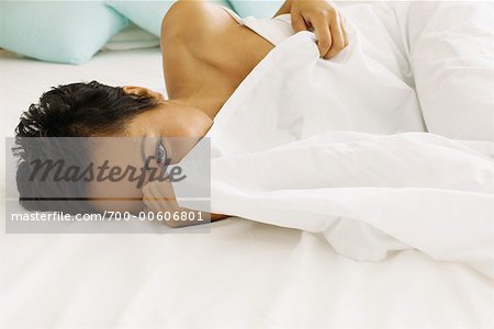 Femme se cachant sous les couvertures