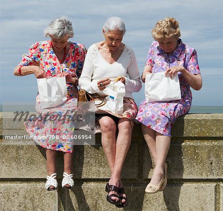 Women Eating Lunch on Brick Wall