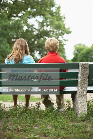 Enfants assis sur un banc de parc