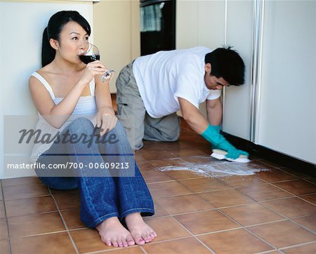 Woman Drinking Wine while Man Scrubs Floor