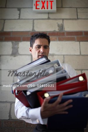 Man Stumbling with Stack of Binders