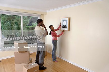 Couple Hanging Picture on Wall of New Home