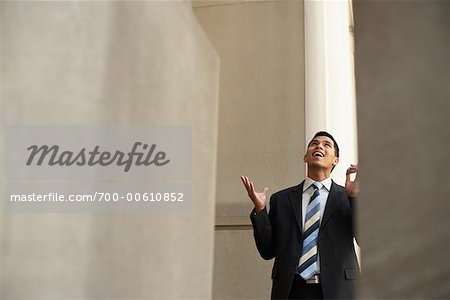 Businessman Looking Up and Holding Cellular Telephone
