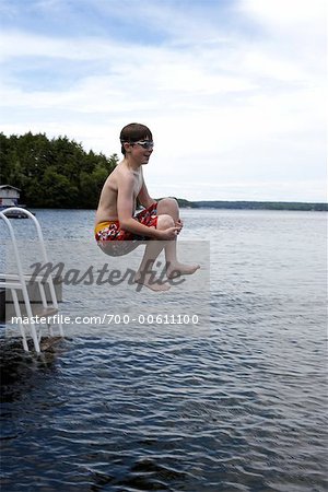 Teen sautant dans le lac Rosseau, Muskoka, Ontario, Canada