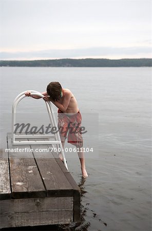 Garçon de tester l'eau du lac, lac Rosseau, Muskoka, Ontario, Canada