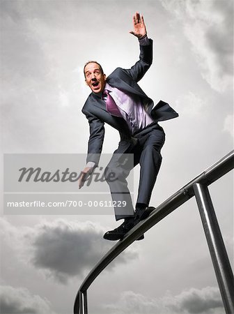 Businessman Balancing On Railing