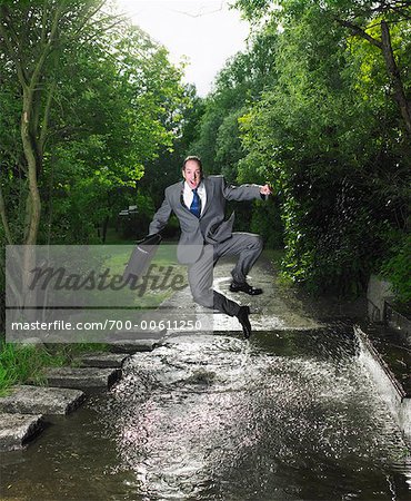 Homme d'affaires Jumping Over Puddle