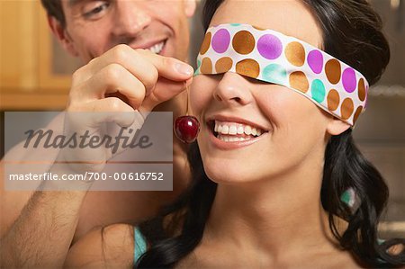 Alimentation de l'homme les yeux bandés femme une cerise