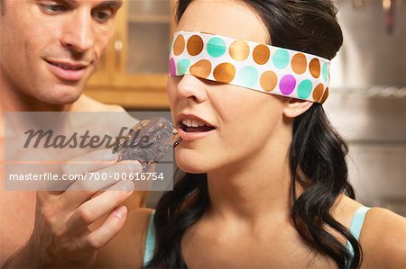 Man Feeding Blindfolded Woman a Brownie