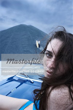 Porträt der Frau sitzt auf der Motorhaube eines Autos
