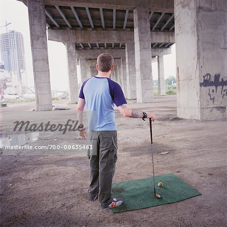 Man Golfing Under Overpass