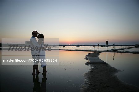 Paar umarmt am Strand bei Sonnenuntergang