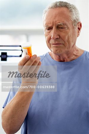 Homme tenant une bouteille de pilules