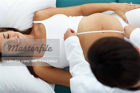 Doctor Measuring Woman's Stomach