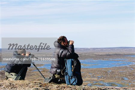 Hommes à la recherche au moyen de jumelles, île Banks, Territoires du Nord-Ouest, Canada