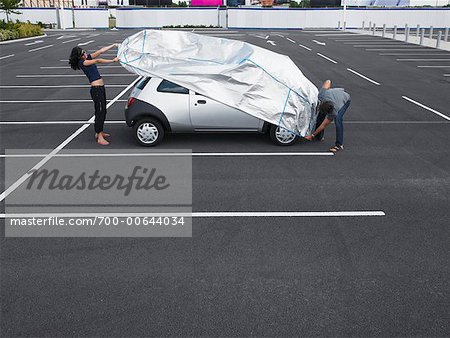 Couple in Parking Lot, Lifting Cover off Car