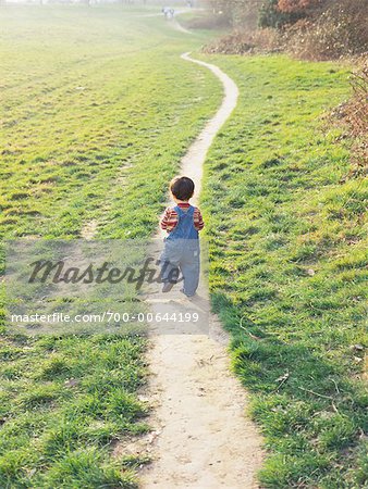 Enfant marchant sur le chemin d'accès au parc