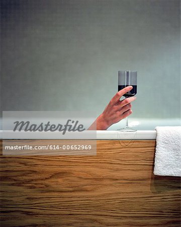 Woman holding a glass of wine in a bath