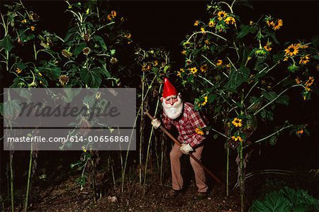 Gnome se cache dans un parterre de fleurs