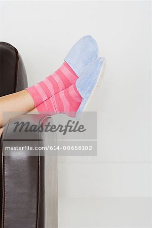 Frau trägt Hausschuhe und gestreifte Socken
